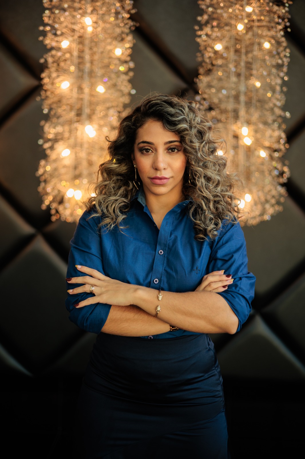 Stefany Rezende, advogada trabalhista, em retrato profissional de braços cruzados